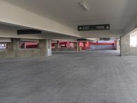 an empty parking garage with signs in the wall and in the floor area above them