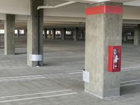 an empty parking lot with a fire hydrant painted white and red on the front of the pole