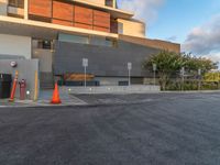 a parking lot with two cones and a parking meter on one of the sides of the buildings