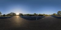 a circular picture of a parking lot and some trees in the sun and with a blue sky