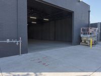 a construction worker sits on a pallet and looks in the large door of a building