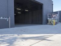 a construction worker sits on a pallet and looks in the large door of a building