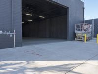 a construction worker sits on a pallet and looks in the large door of a building