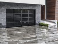 a person walking near an entrance on a rainy day with rain falling on the ground