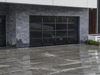 a person walking near an entrance on a rainy day with rain falling on the ground