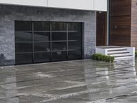 a person walking near an entrance on a rainy day with rain falling on the ground