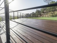 a fenced in deck with a view of the valley below the patio and grassy area