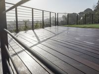 a fenced in deck with a view of the valley below the patio and grassy area