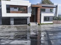 a house that has some water on the ground in front of it and in front of it