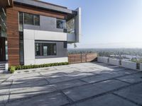 the exterior and landscape of a modern house in los angeles, california with stone and wood