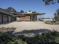 a large stone walkway leading to a home on the beach that is made of wood and concrete