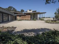 a large stone walkway leading to a home on the beach that is made of wood and concrete