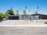 this mid century modern home features an open driveway, garages and two car garages