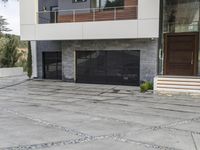 the exterior and landscape of a modern house in los angeles, california with stone and wood