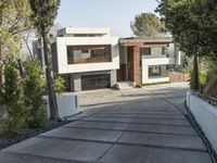 the exterior and landscape of a modern house in los angeles, california with stone and wood