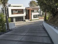 the exterior and landscape of a modern house in los angeles, california with stone and wood