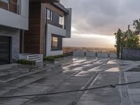 there is a skateboard sitting on the concrete sidewalk in front of a house at dusk