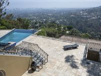 a tiled backyard with an open area and a plunge pool, surrounded by trees, and other buildings