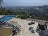 a tiled backyard with an open area and a plunge pool, surrounded by trees, and other buildings