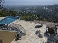 a tiled backyard with an open area and a plunge pool, surrounded by trees, and other buildings