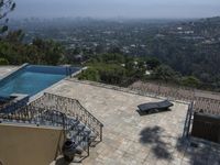 a tiled backyard with an open area and a plunge pool, surrounded by trees, and other buildings