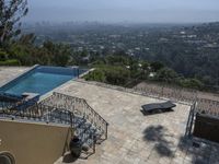 a tiled backyard with an open area and a plunge pool, surrounded by trees, and other buildings