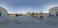 the 360 - view of a building with a bench in it and multiple pots on the porch