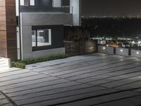 a concrete patio with planters on the sides of it at night overlooking a city