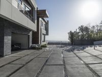 the exterior and landscape of a modern house in los angeles, california with stone and wood