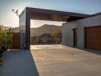 large garage and open garage door at sunset with mountain view in background with sun reflecting over mountain