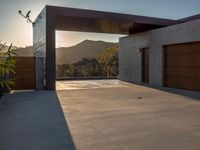 large garage and open garage door at sunset with mountain view in background with sun reflecting over mountain