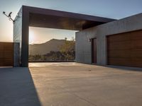 large garage and open garage door at sunset with mountain view in background with sun reflecting over mountain