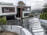 a house on a residential street is flooded with water from a large puddle in the driveway