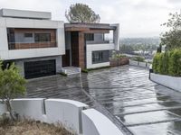 a house on a residential street is flooded with water from a large puddle in the driveway