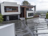 a house on a residential street is flooded with water from a large puddle in the driveway