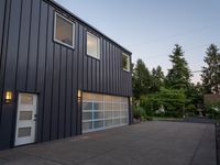 a garage door sitting next to a building with two windows and a bike rack in the front