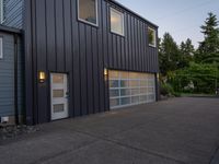 a garage door sitting next to a building with two windows and a bike rack in the front