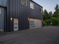 a garage door sitting next to a building with two windows and a bike rack in the front