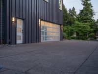 a garage door sitting next to a building with two windows and a bike rack in the front