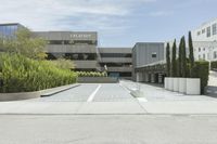 an empty parking lot with large trees outside the building and outside view of the parking lot