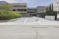 an empty parking lot with large trees outside the building and outside view of the parking lot