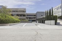 an empty parking lot with large trees outside the building and outside view of the parking lot