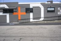 a gray building with orange crosses painted on it's side is shown here and has the word asl