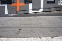 a gray building with orange crosses painted on it's side is shown here and has the word asl