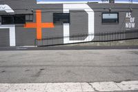 a gray building with orange crosses painted on it's side is shown here and has the word asl