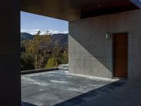 a gray concrete building with stairs and door at the top of the floor next to it is steps leading down to the doorway