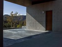 a gray concrete building with stairs and door at the top of the floor next to it is steps leading down to the doorway