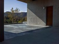 a gray concrete building with stairs and door at the top of the floor next to it is steps leading down to the doorway