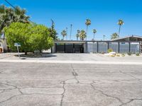 the house that looks like it is in a suburban neighborhood with palm trees on both sides of