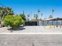 the house that looks like it is in a suburban neighborhood with palm trees on both sides of